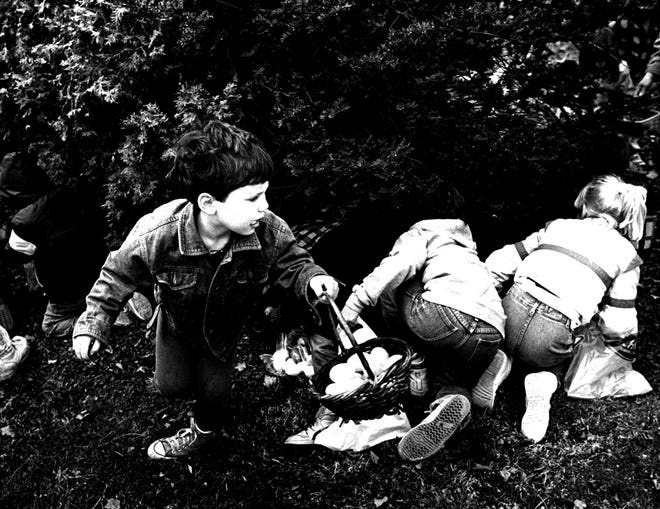 Children scramble to find hidden eggs at a 1989 Easter egg hunt.