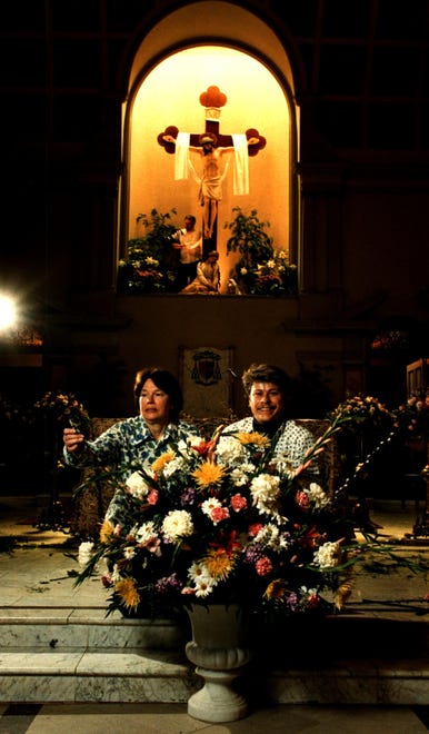 Rosemary Neville and Anthony Mombro work on alter flowers for Easter at St. Peter church in Wilmington in 1989. Jeff Neville arranges flowers behind them near the crucifix.
