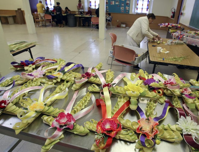 Chila Ortiz of New Castle puts the finishing touches on a palm cross as a group of volunteers works to produce 250 of the Easter crosses at St. Paul's Catholic Church in Wilmington, Saturday, April 12, 2014.