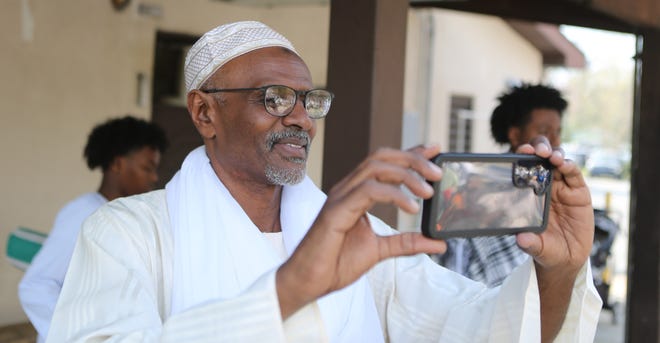 Bashir Mohuammad, of New Castle, takes video of the crowd assembled in Ogletown to celebrate Eid al-Fitr on Wednesday April 10, 2024.