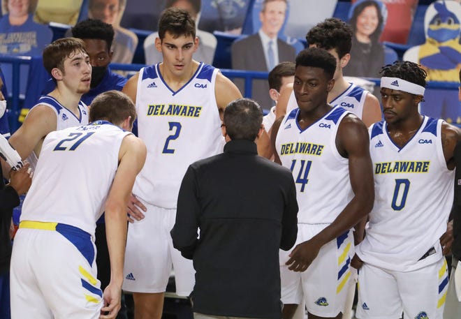 Six of Delaware's seven available scholarship players (from left) Johnny McCoy, Andrew Carr, Dylan Painter, Ebby Asamoah, Gianmarco Arletti (obscured) and Ryan Allen huddle in the first half of the Blue Hens' 74-56 winat the Bob Carpenter Center Friday, Jan. 15, 2021.