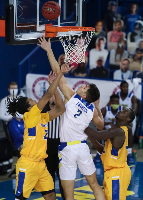 Delaware's Dylan Painter puts up a shot between Hofstra's Kvonn Cramer (left) and Isaac Kante in the second half of the Blue Hens' 74-56 win at the Bob Carpenter Center Friday, Jan. 15, 2021.