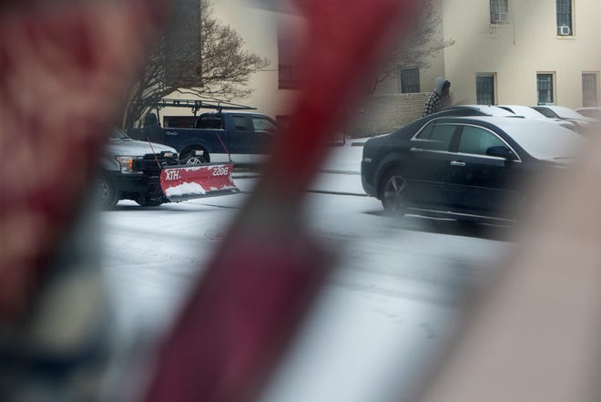 A truck blow is seen in a reflection as it makes its way down Shipley Street Thursday, Feb. 18, 2021, in Wilmington.