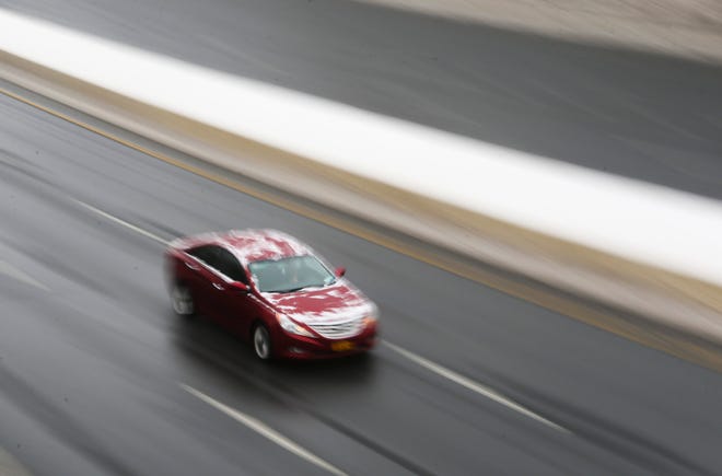 A car cruises on mostly ice-free I-95 in Wilmington during a quiet afternoon rush hour after a snowstorm moved through the area Thursday, Feb. 18, 2021.