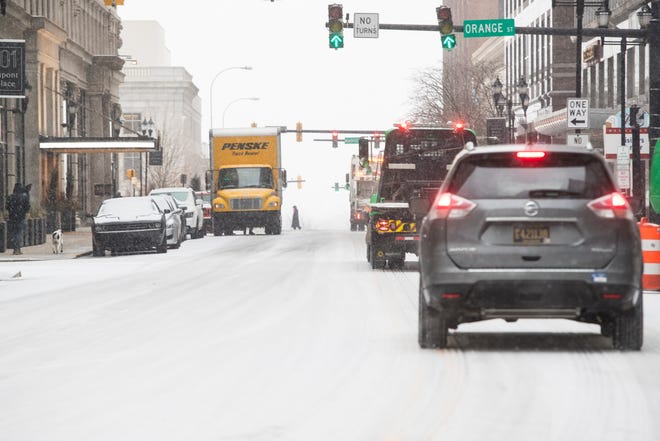 Snow covers West 10th Street as morning commuters drive through town Thursday, Feb. 18, 2021, in Wilmington.