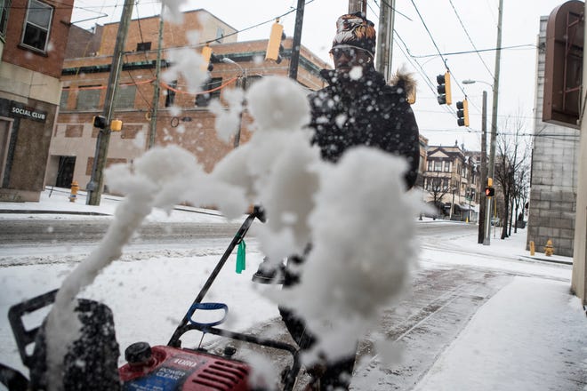 Marlon Rochester use a snowplow to clean the sidewalk on West 8th Street Thursday, Feb. 18, 2021, in downtown Wilmington.