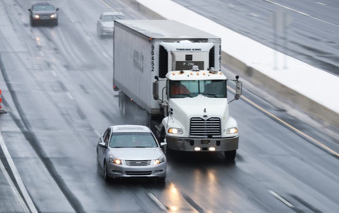 A car and semi-tractor trailer nearly collide as they try to occupy the same lane on south I-95 in Wilmington after a snowstorm moved through the area Thursday, Feb. 18, 2021.
