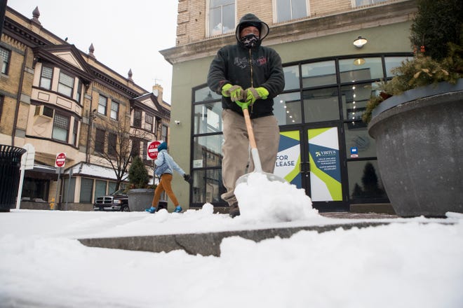 Jimmy Bottomley shovels snow off the sidewalk on Market Street Thursday, Feb. 18, 2021, in Wilmington.