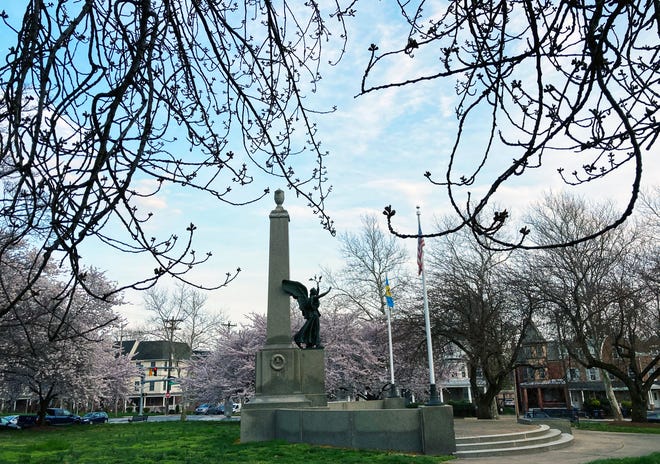 Cherry trees serve as a backdrop for the Soldiers and Sailors Memorial in Brandywine Park, Wednesday, April 5, 2023. Some trees near the World War One memorial have yet to bloom but are on the verge. Others are well into their bloom cycle and will soon drop their blossoms.