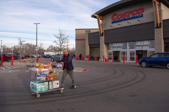 A man exits a Costco in Colorado with a full grocery cart in January.